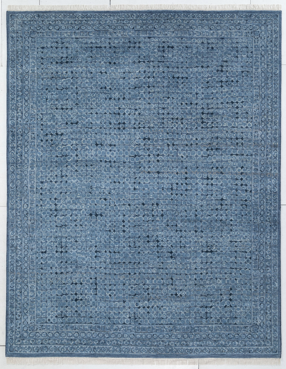 A rectangular blue area rug with a distressed, vintage-style traditional pattern and a decorative border, shown flat against a light background.