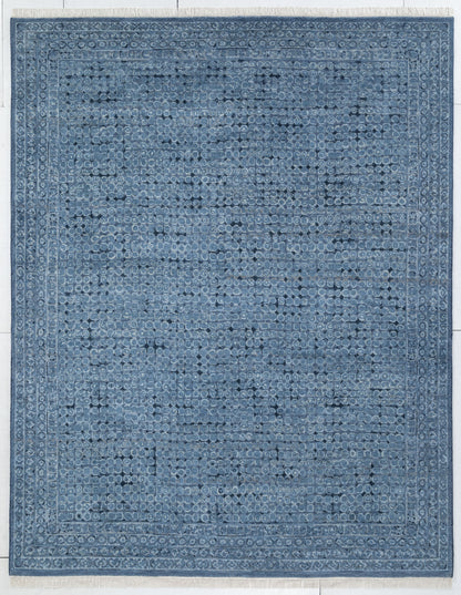 A rectangular blue area rug with a distressed, vintage-style traditional pattern and a decorative border, shown flat against a light background.