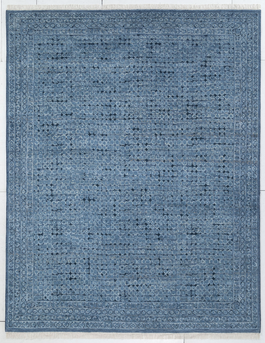 A rectangular blue area rug with a distressed, vintage-style traditional pattern and a decorative border, shown flat against a light background.
