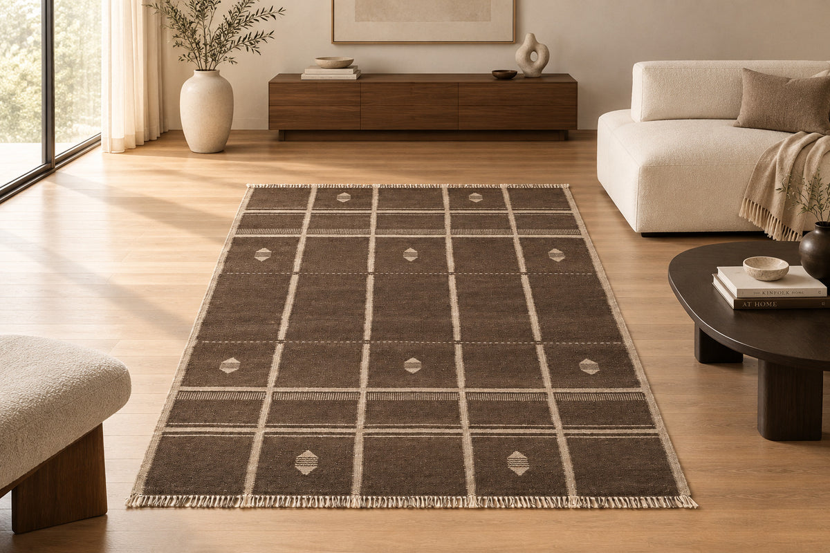 A rectangular woven area rug with a dark brown base and cream grid lines, diamond motifs, and fringe on all four sides.