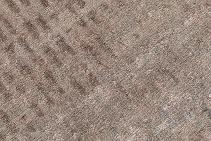 A close-up texture shot of a brown and beige patterned carpet or fabric with a heathered, woven appearance.Rust colored hand knotted 4x5 ft rug made in bhadohi