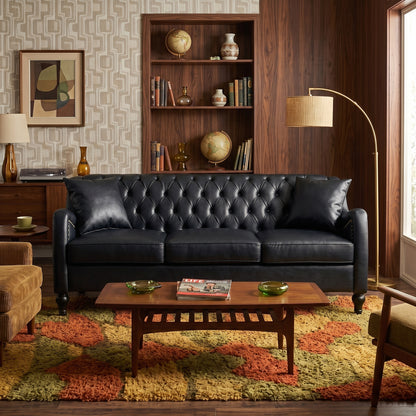 A black tufted leather sofa in a styled living room with a wood bookshelf, patterned wallpaper, a multicolor rug, and a wooden coffee table. black  3 Seater