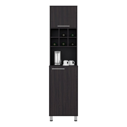 A tall, narrow dark wood beverage bar cabinet with a top storage compartment, open shelving with wine bottle holders, a countertop with a glass and two white mugs, and a lower cabinet door, shown on a plain white background. Wenge