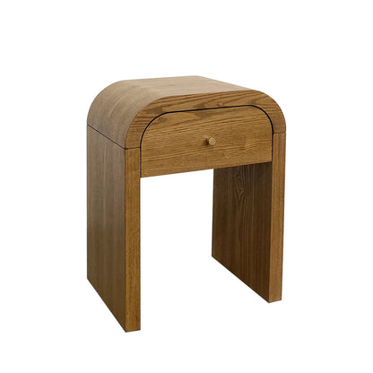 A mid-century modern Walnut Brown wooden side table with a single drawer, featuring a curved top and blocky legs, crafted from medium brown wood with a small round wooden knob.