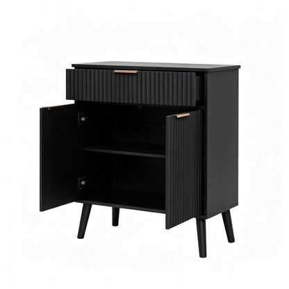 A modern black side cabinet with a single ribbed drawer and two open doors, showing an interior shelf. The cabinet has a matte black finish, tapered legs, and small gold-toned hardware handles.