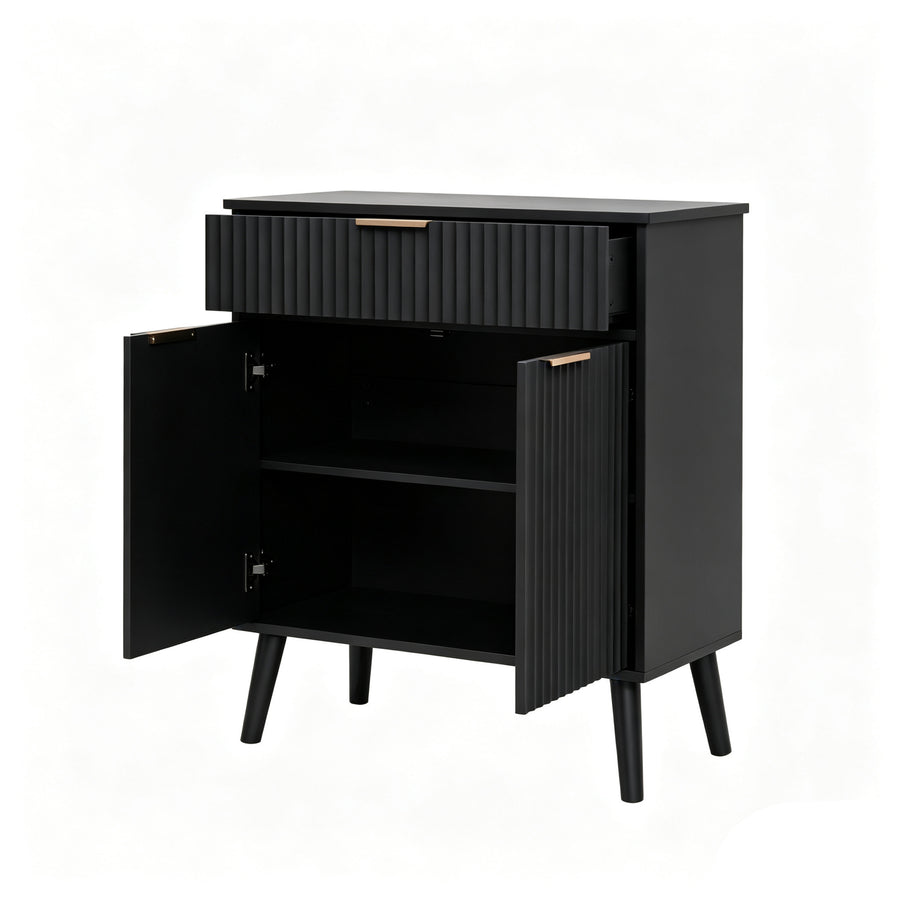 A modern black side cabinet with a single ribbed drawer and two open doors, showing an interior shelf. The cabinet has a matte black finish, tapered legs, and small gold-toned hardware handles.