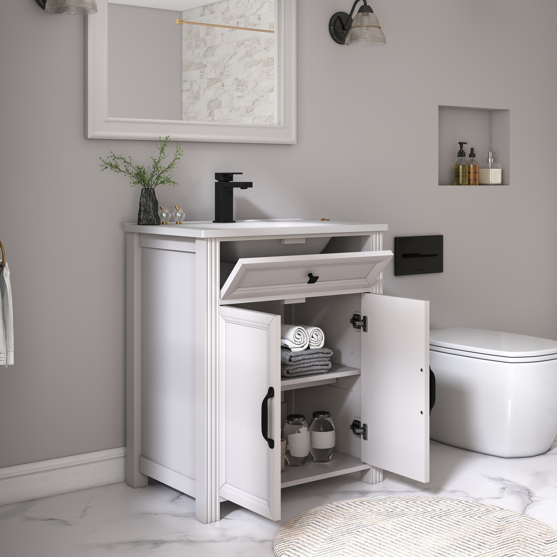 A white bathroom vanity cabinet with an open lower door showing towels and jars, set beside a white toilet in a modern bathroom with gray walls and marble flooring.