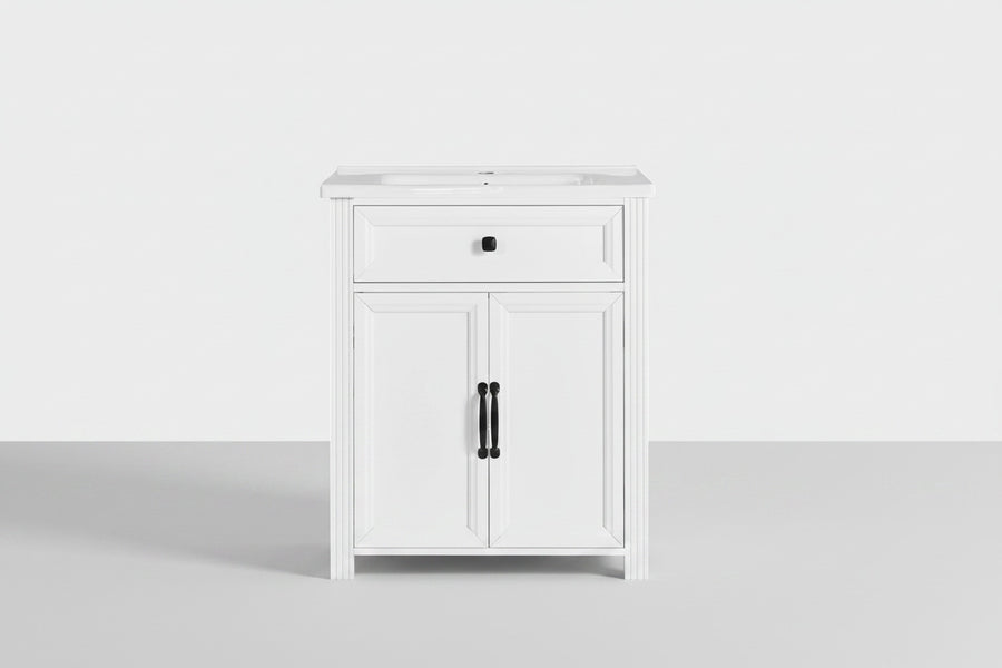 A white single-sink bathroom vanity cabinet with a single drawer and two cabinet doors, featuring black hardware, shown against a plain white background.