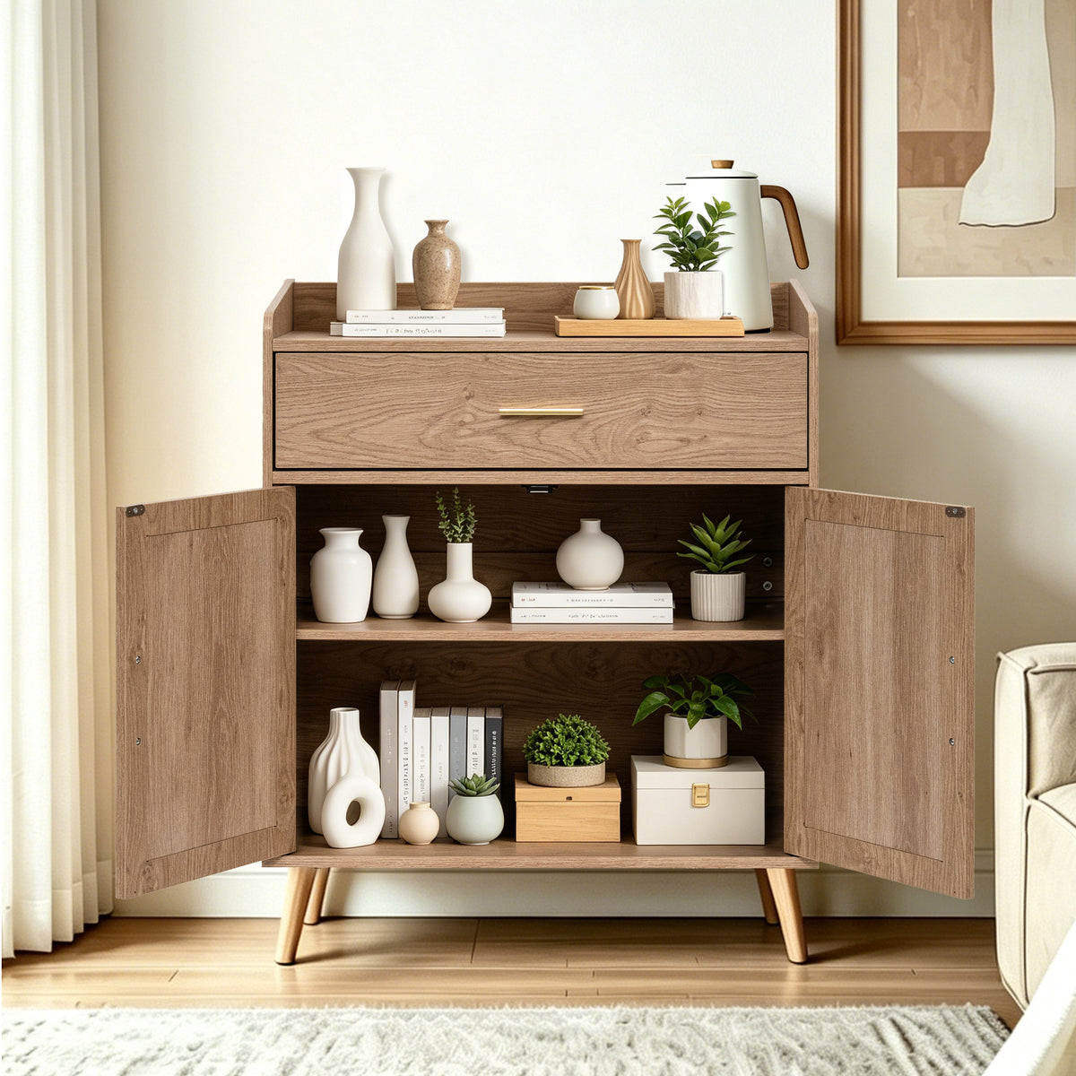 A mid-century modern natural  wooden side cabinet with a single drawer and two open doors, styled with books, vases, and small potted plants in a bright living room.