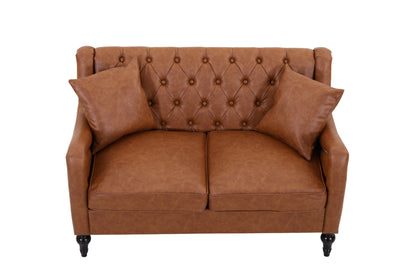 A brown faux leather loveseat sofa with a tufted diamond pattern on the backrest, two matching throw pillows, and dark turned wooden legs, shown against a plain white background. light brown loveseat