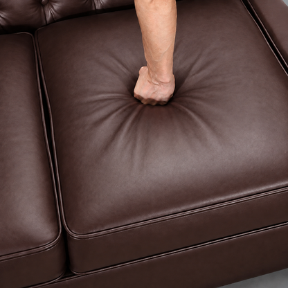 A close-up of a dark brown leather sofa cushion being pressed down by a person's fist, showing the material's texture and resilience. Dark Brown 3 Seater Solo loveseat