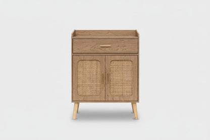 A mid-century modern wooden cabinet with a single drawer and two cane-embossed doors, featuring light wood legs and brass handles, shown on a plain natural background.