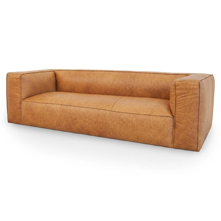 A modern low-profile leather sofa in a warm tan/caramel color, shown from a three-quarters angle against a plain white background.