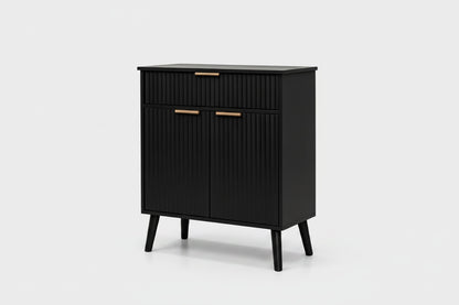 A modern black cabinet with a ribbed vertical texture, featuring two drawers on top and two doors below, accented with slim gold handles and supported by tapered legs, shown against a light gray background.