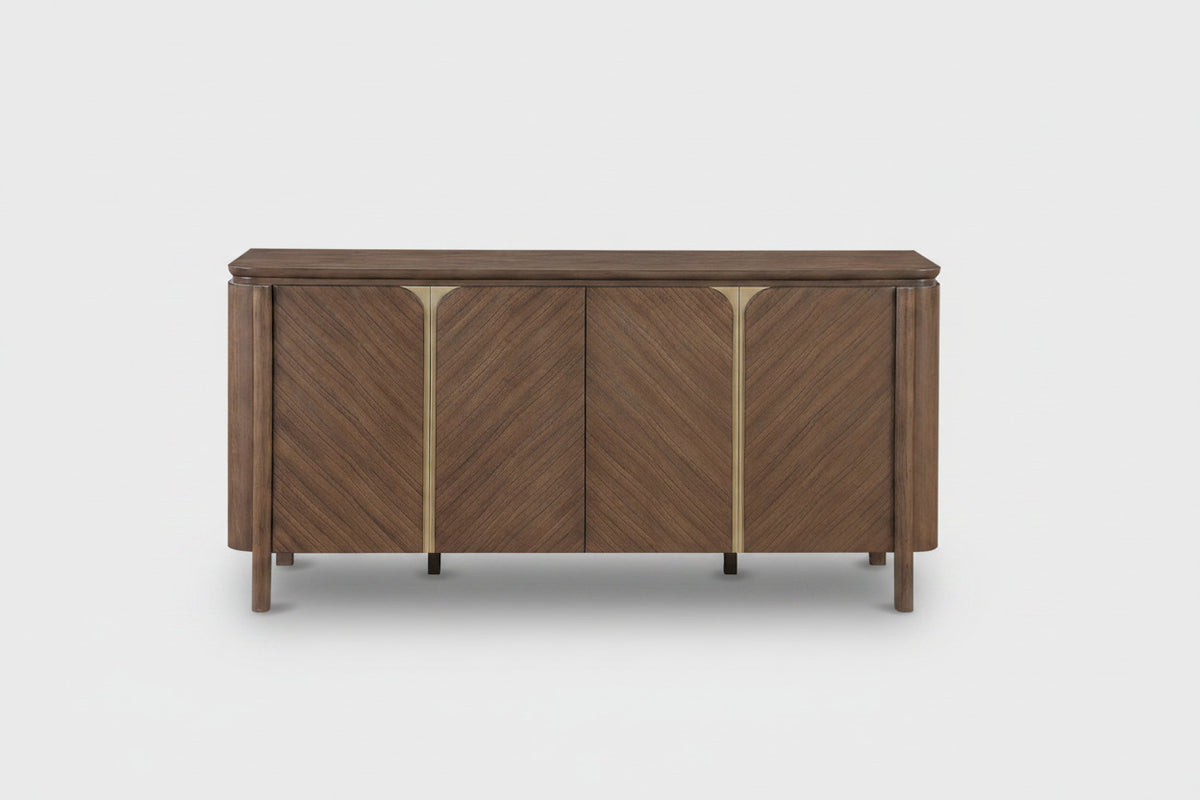 A mid-century modern wooden sideboard with three doors featuring a chevron wood grain pattern and polished brass vertical accents, shown against a plain white background.